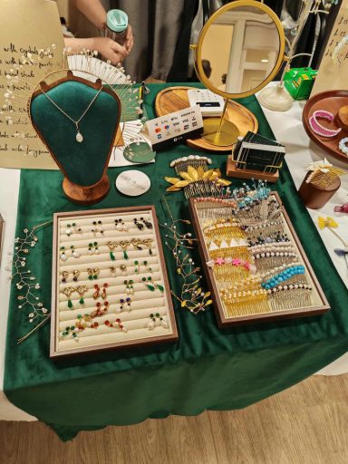 Necklaces, earrings, and brooches displayed on a green tablecloth.